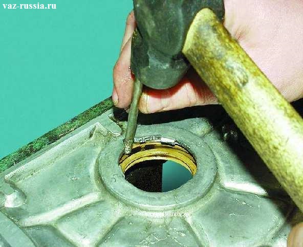 Извлечение сальника из отверстия в крышке, при помощи молотка и бородка