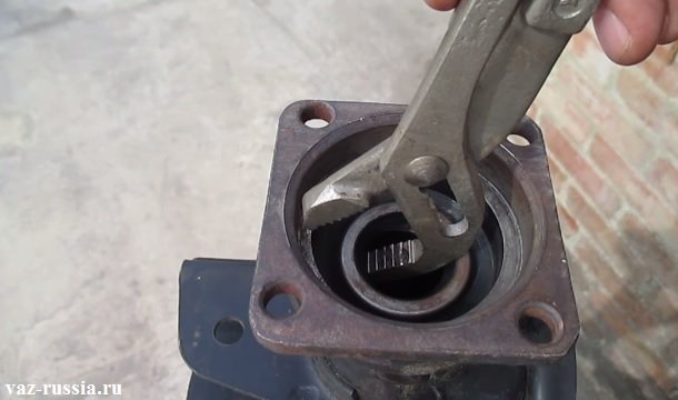 Вынимание пассатижами раздвижными сальника из балки в которую полуось входит